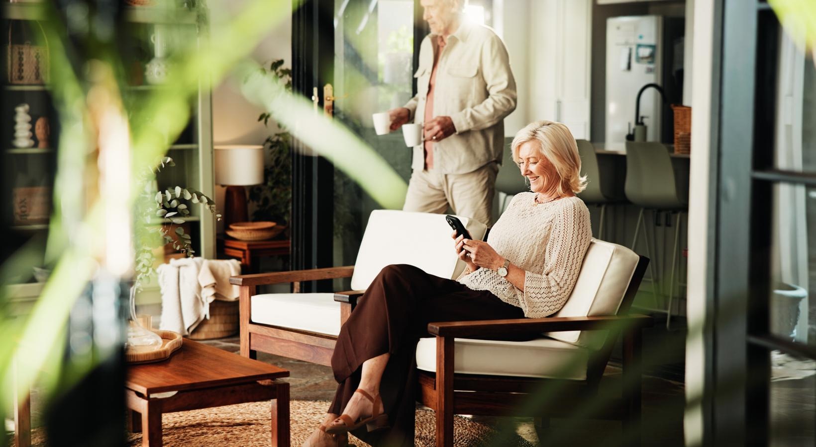 a person sitting in a chair and looking at a phone