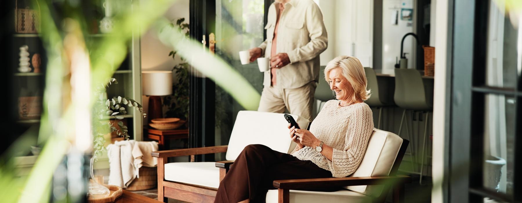 a person sitting in a chair and looking at a phone