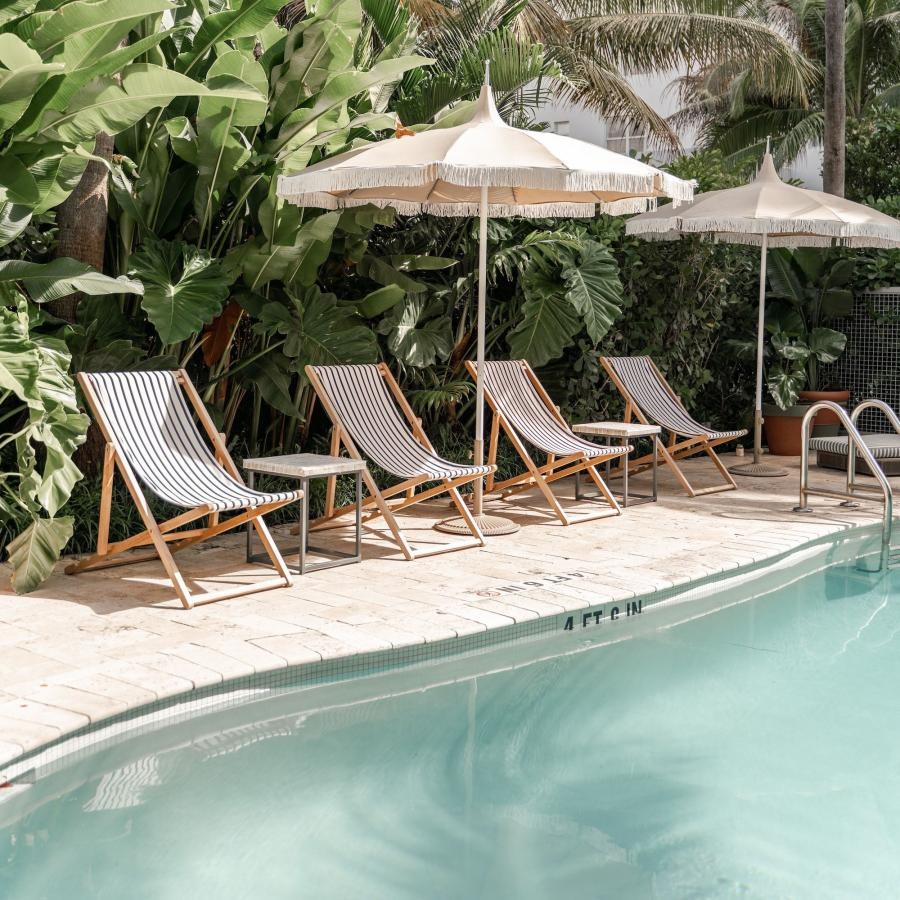 a pool with chairs and umbrellas by it